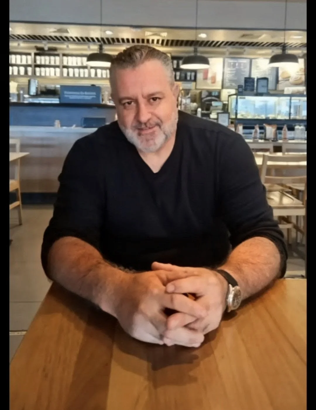 Jorge Dias sentado à mesa em um ambiente descontraído