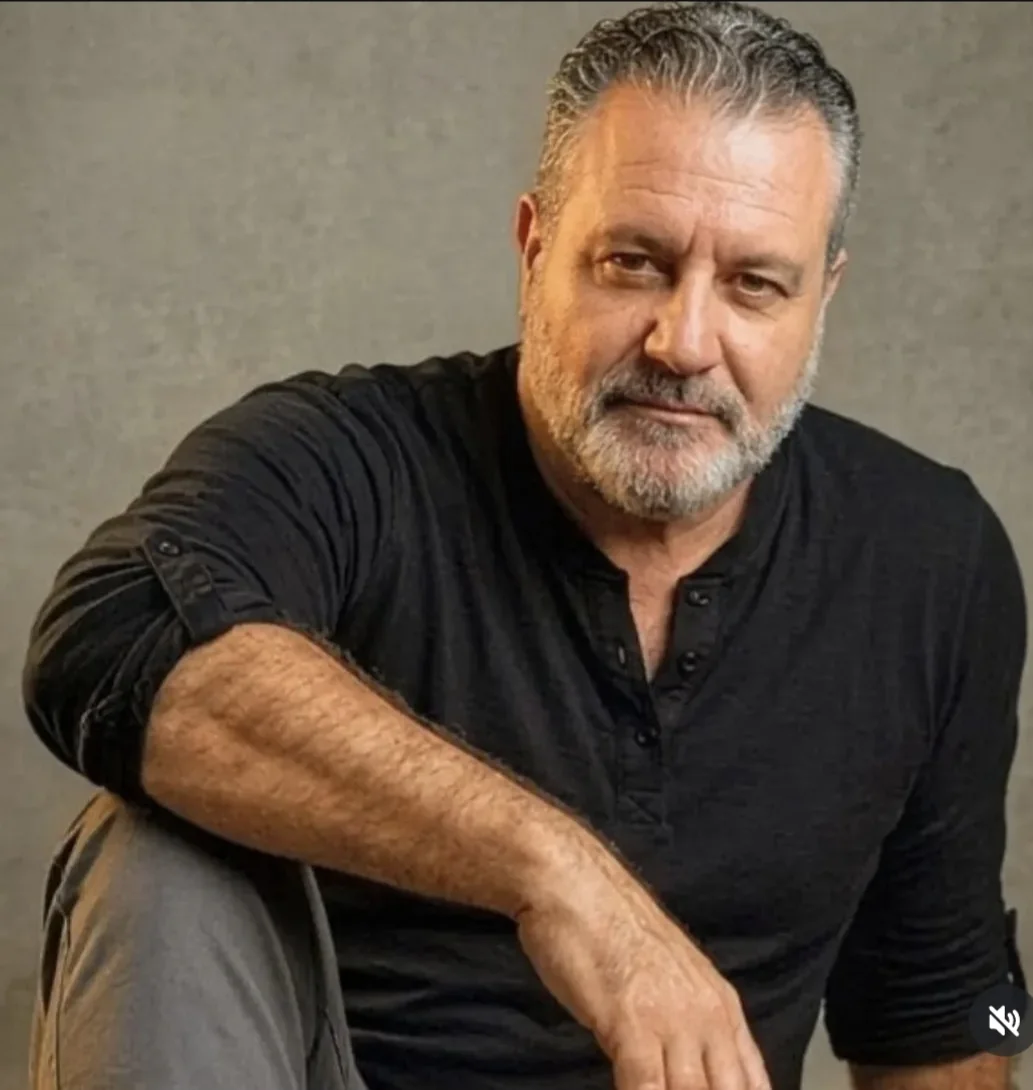 Retrato de Jorge Dias usando camisa preta em ambiente interno